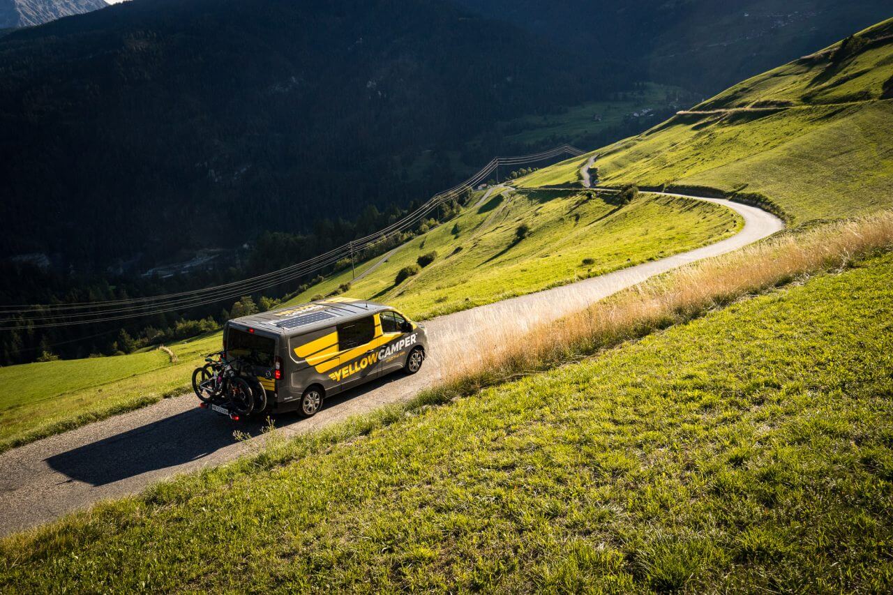 yellowcamper campervan on a road in switzerland